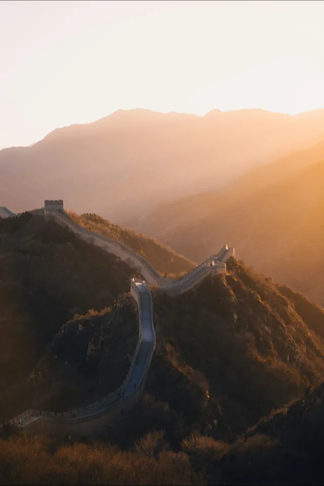 The Great Wall of China snaking over the hills at golden hour