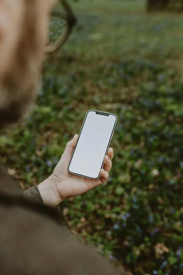 A hand holding a smartphone with a blank screen
