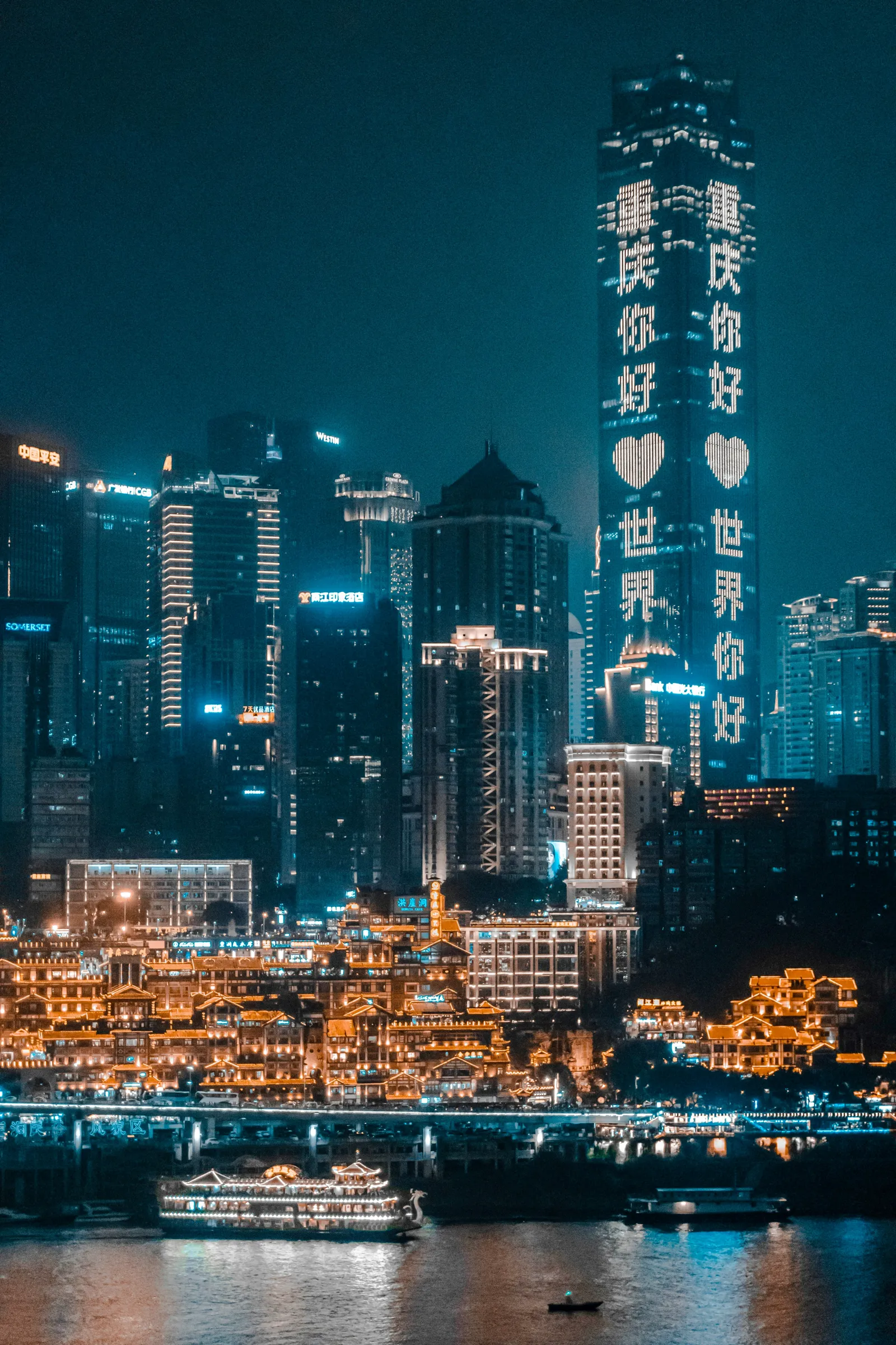 The glowing Hongya Cave complex reflected in the Yangtze at dusk